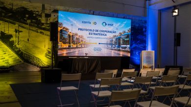 Room prepared for the signing of the strategic cooperation protocol between Carris and STCP, with screen, podium and chairs for the public.